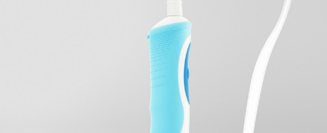 Eine Handzahnbürste steht einer elektrischen Zahnbürste gegenüber, denn es wird gefragt: wer putzt besser?